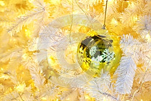 Golden Ball Bauble Reflecting Snow Flakes on Christmas tree