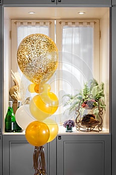 Golden balloons. Glittery and golden balloons for celebration or special occasion by the window