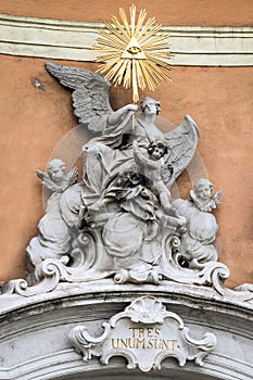 Golden Baroque statue on the wall of a historic building in Brat