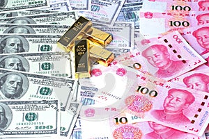 Golden bars on dollar banknote and yuan banknote  lay spread double