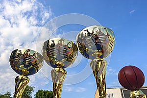 Golden basketball cups against the sky