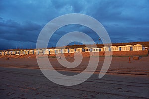 Golden beach cabins at Zandvoort in the Netherlands illuminated by the sunset