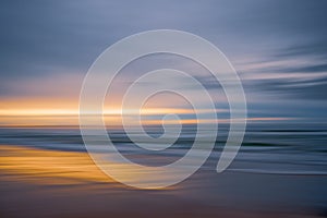 Golden beach sunset. Beautiful abstract seascape. Soft golden light, blue sea, and cloudy sky