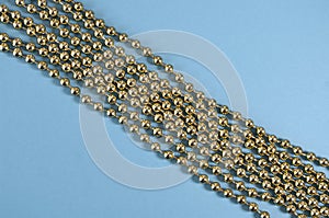 Golden beads on blue background, christmas tree decoration. Background design