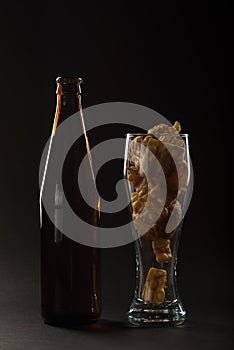 Golden beer in a bottle and in a glass and snack nuts, squid and