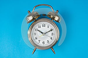 Golden bell alarm clock isolated on blue background