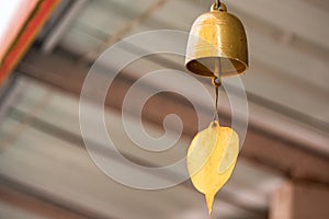 A golden bell hanging under the Thai temple roof