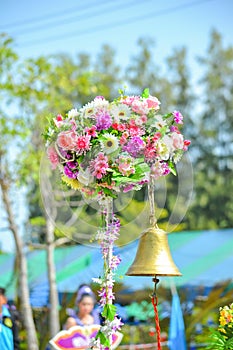 A golden bell under artificial flowers