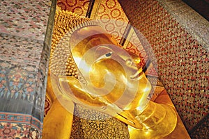 Golden big face of reclining buddha statute at public temple Wat Phra Chetuphon locally known as Wat Pho in Bangkok Thailand