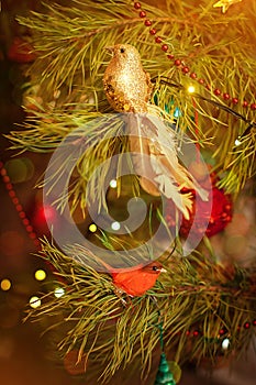 Golden bird toy for christmas decoration haning on a Christmas tree