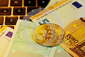 Golden bitcoin on 50 and 100 Euro banknotes background, cryptocurrency financial concept of global economic crisis. Modern income