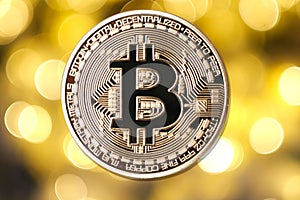 Golden bitcoin on blurred light background