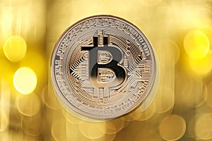 Golden bitcoin on blurred light background