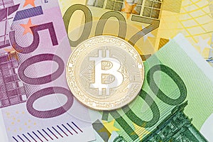 Golden Bitcoin close-up. Euro currency as a background. Macro ph