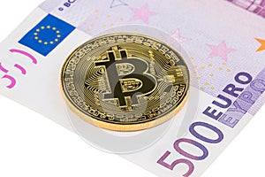 Golden Bitcoin close-up on euro currency background.