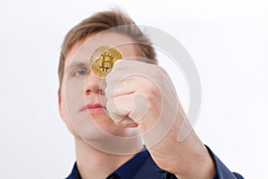 Golden bitcoin coin with gold symbol in man hand isolated on white background. Businessman and success concept. Selective focus