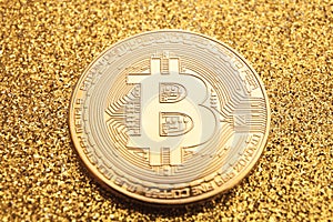Golden bitcoin coin on golden background close up
