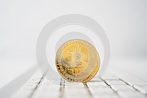 Golden bitcoin coin on laptop computer keyboard