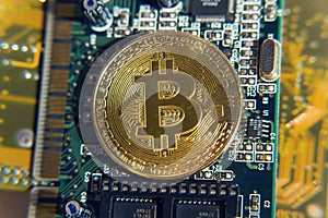 Golden bitcoin coin lying on computer motherboard, cryptocurrency mining concept