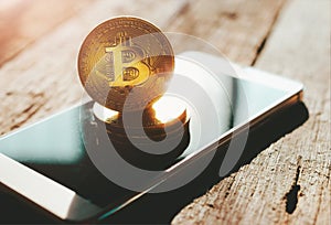 golden bitcoin coin on mobile phone crypto Currency background c photo
