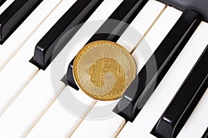 Golden Bitcoin Coin on Piano Keys closeup