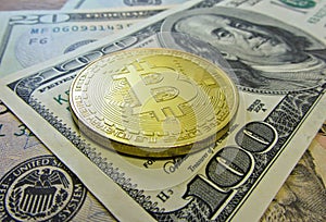 Golden bitcoin coin on us dollars close up