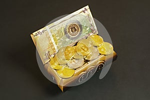 Golden bitcoin coins and banknote in the treasure trove, cryptocurrency in wooden chest, gift, decoration on black paper