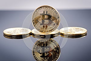 Golden bitcoin coins on a dark background with reflection. Virtual currency. Crypto currency. New virtual money.