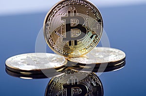 Golden bitcoin coins on a dark background with reflection. Virtual currency. Crypto currency. New virtual money.