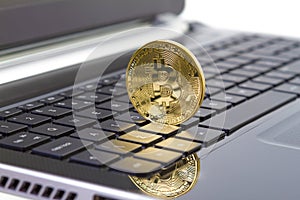 Golden bitcoin digital currency on laptop keyboard