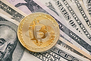 Golden bitcoin on dollar bills