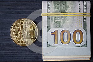 Golden bitcoin on a hundred-dollar bills.