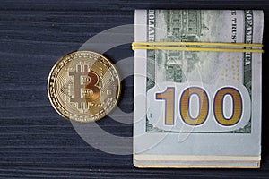 Golden bitcoin on a hundred-dollar bills.