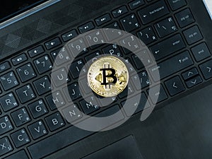 Golden bitcoin on keypad of laptop black color the digital money cryptocurrency concept