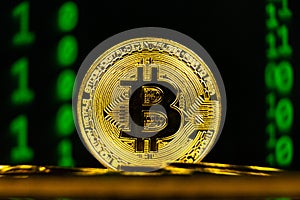 Golden bitcoin macro shot with binary code background