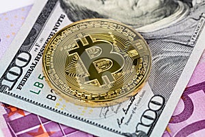 Golden bitcoin metallic coin over dollar and euro banknotes