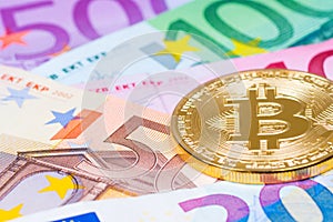 golden bitcoin metallic coin over euro banknotes, future financial technology concept