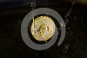 Golden bitcoin motion fall into the water with the water splash