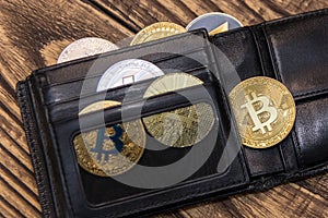 Bitcoin and ethereum lie in black wallet in mans hand closeup