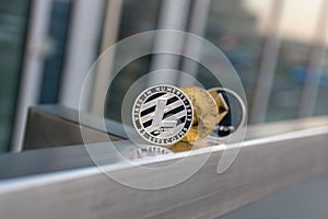 Golden bitcoin silver litecoin and ethereum on metal handrail