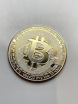 Golden bitcoin on silver metal background, bitcoin is most popular crypto currency coin with copy space behind bitcoin
