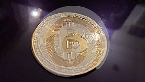 Golden bitcoin on silver metal background, bitcoin is most popular crypto currency coin with copy space behind bitcoin