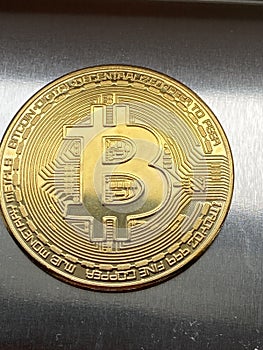 Golden bitcoin on silver metal background, bitcoin is most popular crypto currency with copy space