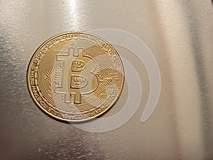 Golden bitcoin on silver metal background, bitcoin is most popular crypto currency with copy space