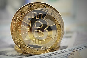 Golden Bitcoin standing on banknotes. Closeup, Macro shot