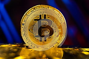 Golden bitcoin standing on pile of coins with blockchain technology background