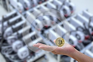 Golden Bitcoin virtual symbol on hand man on computer bitcoin mining blurred background