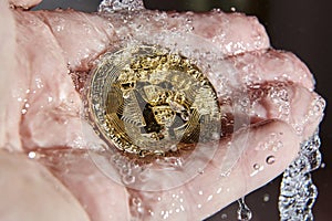 Golden bitcoin and water splash. Money laundering