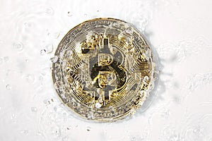 Golden bitcoin and water splash. Money laundering