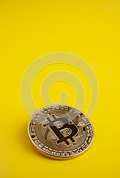 Golden bitcoin on a yellow background